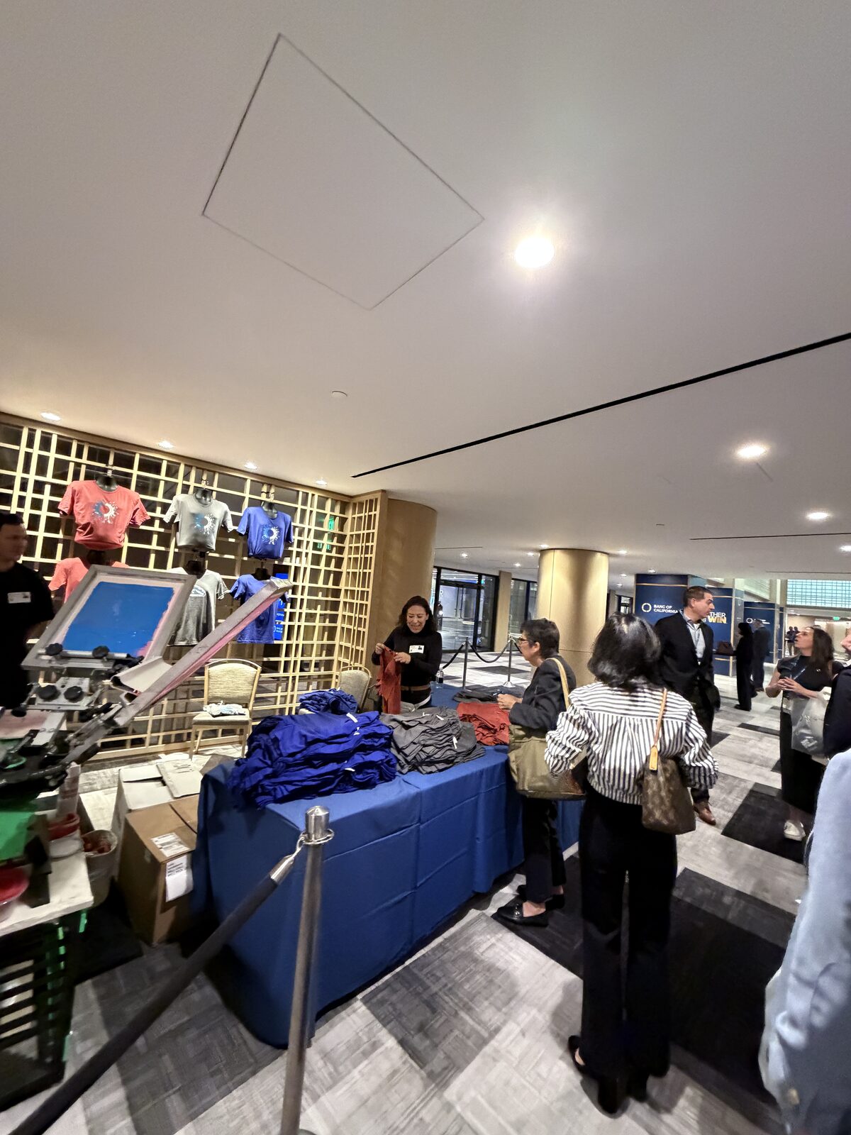 Guest receiving a completed printed shirt at a live merch bar
