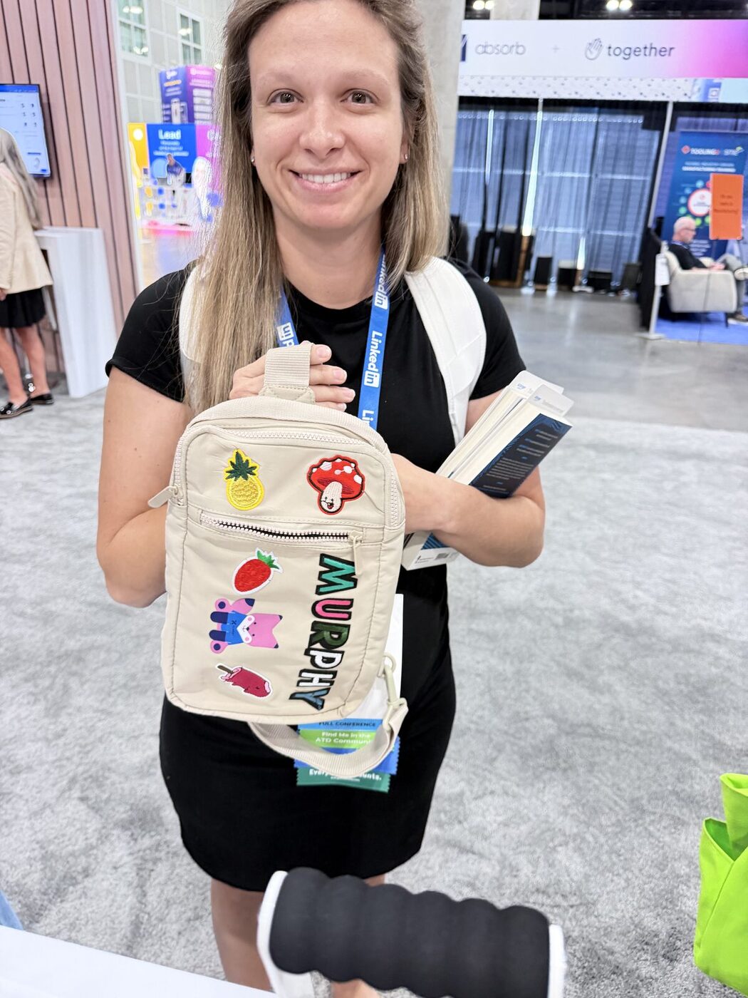 Guests holding custom canvas totes printed at a wedding merch bar